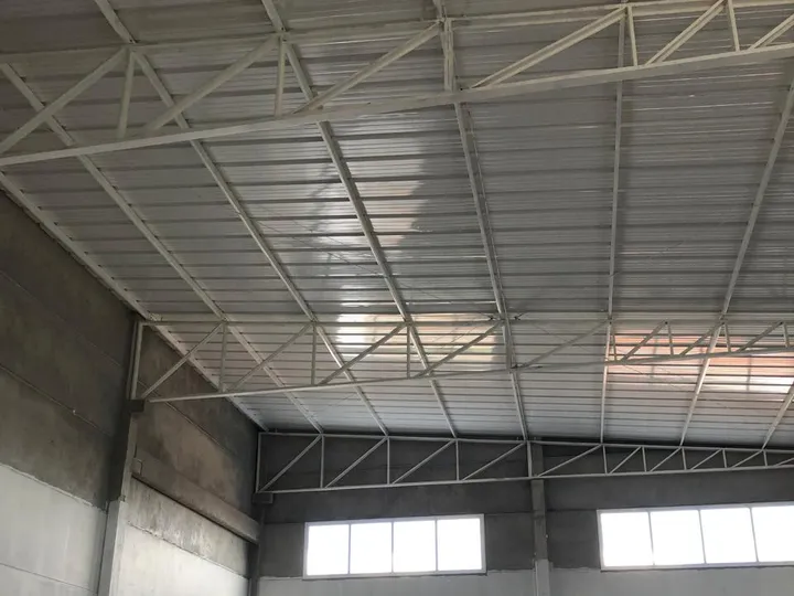 Tesouras metálicas e telhado instalados num pavilhão pré-moldado Gemold